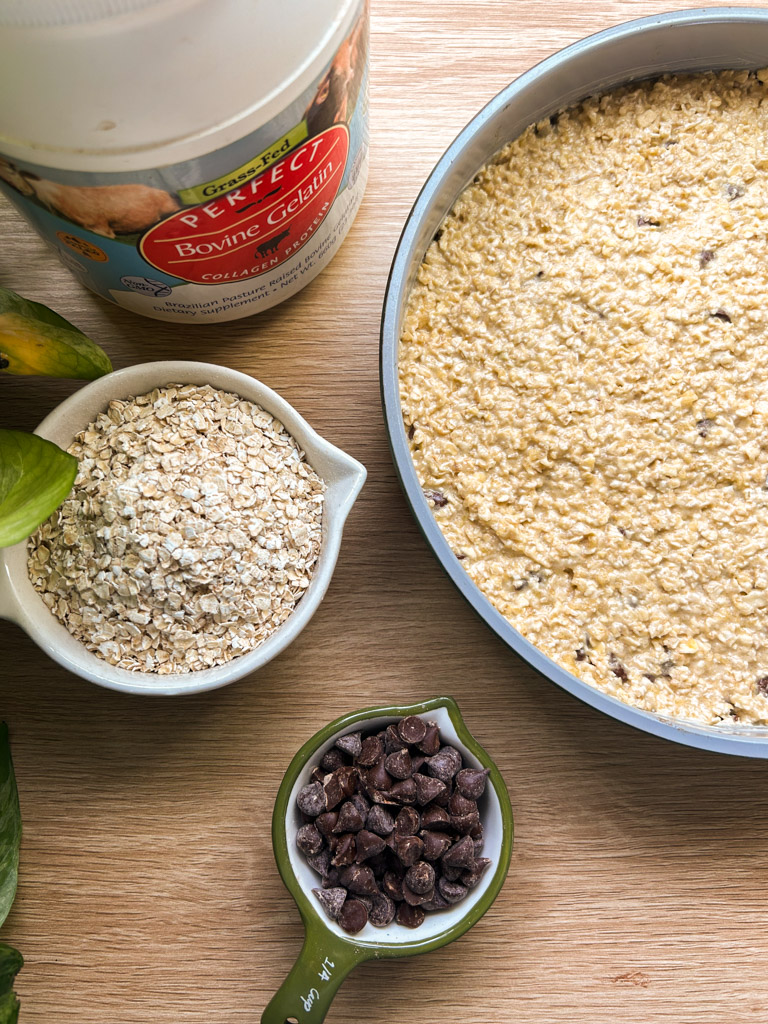 measuring cups of chocolate chips and oats with a container of bovine gelatin sit next to a prepared oatmeal bake