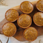 pumpkin muffins sitting on a wooden cutting board ready to be served