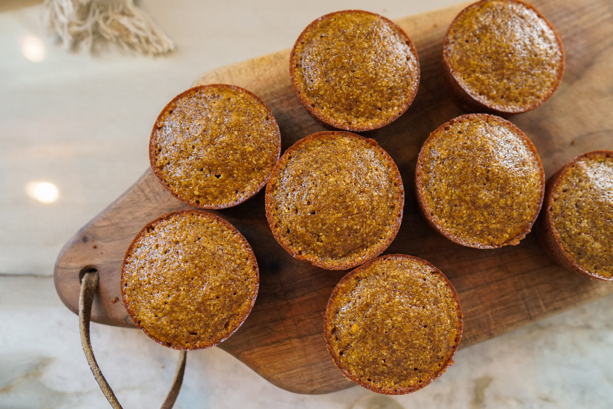 pumpkin muffins sitting on a wooden cutting board ready to be served