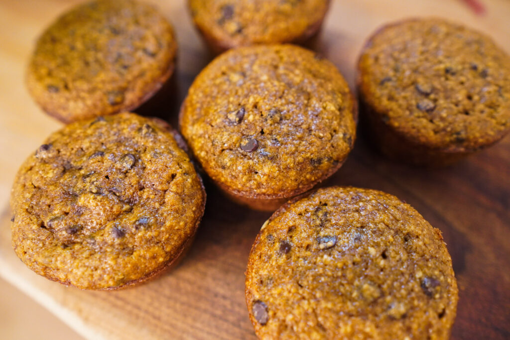 pumpkin muffins sitting on a wooden cutting board ready to be served