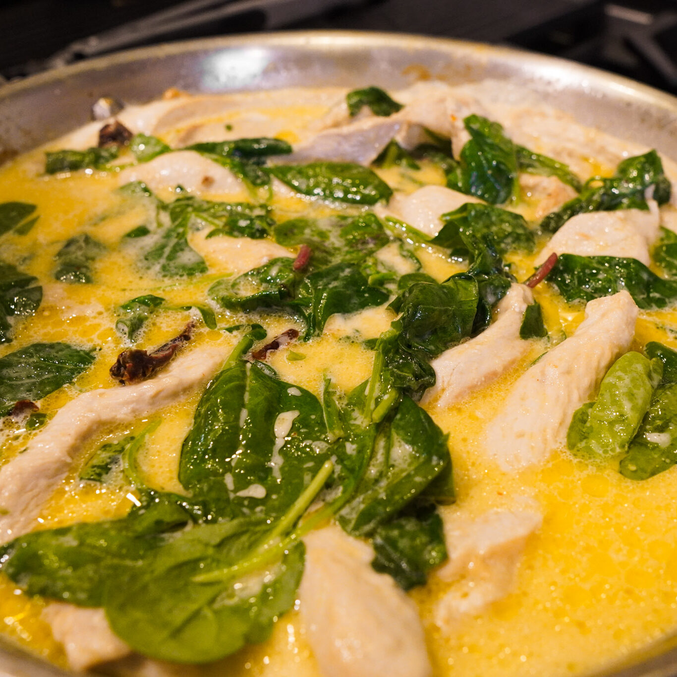 a skillet of chicken, spinach and creamy sauce